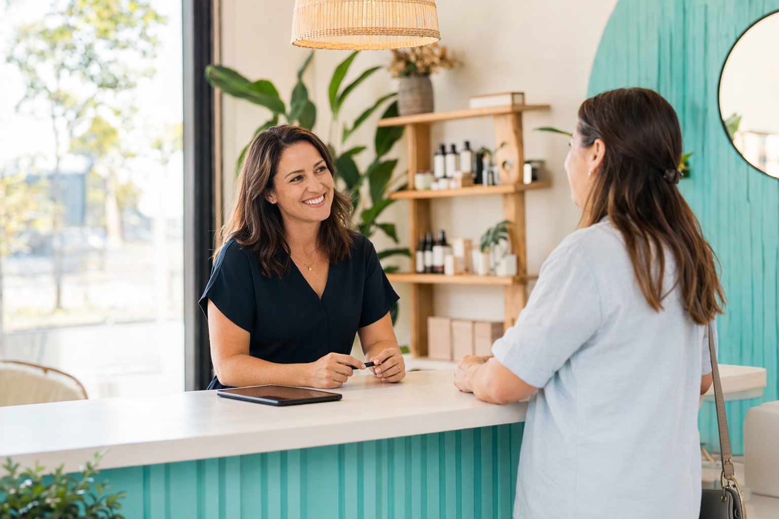 A small business owner chatting with a customer at a bright counter